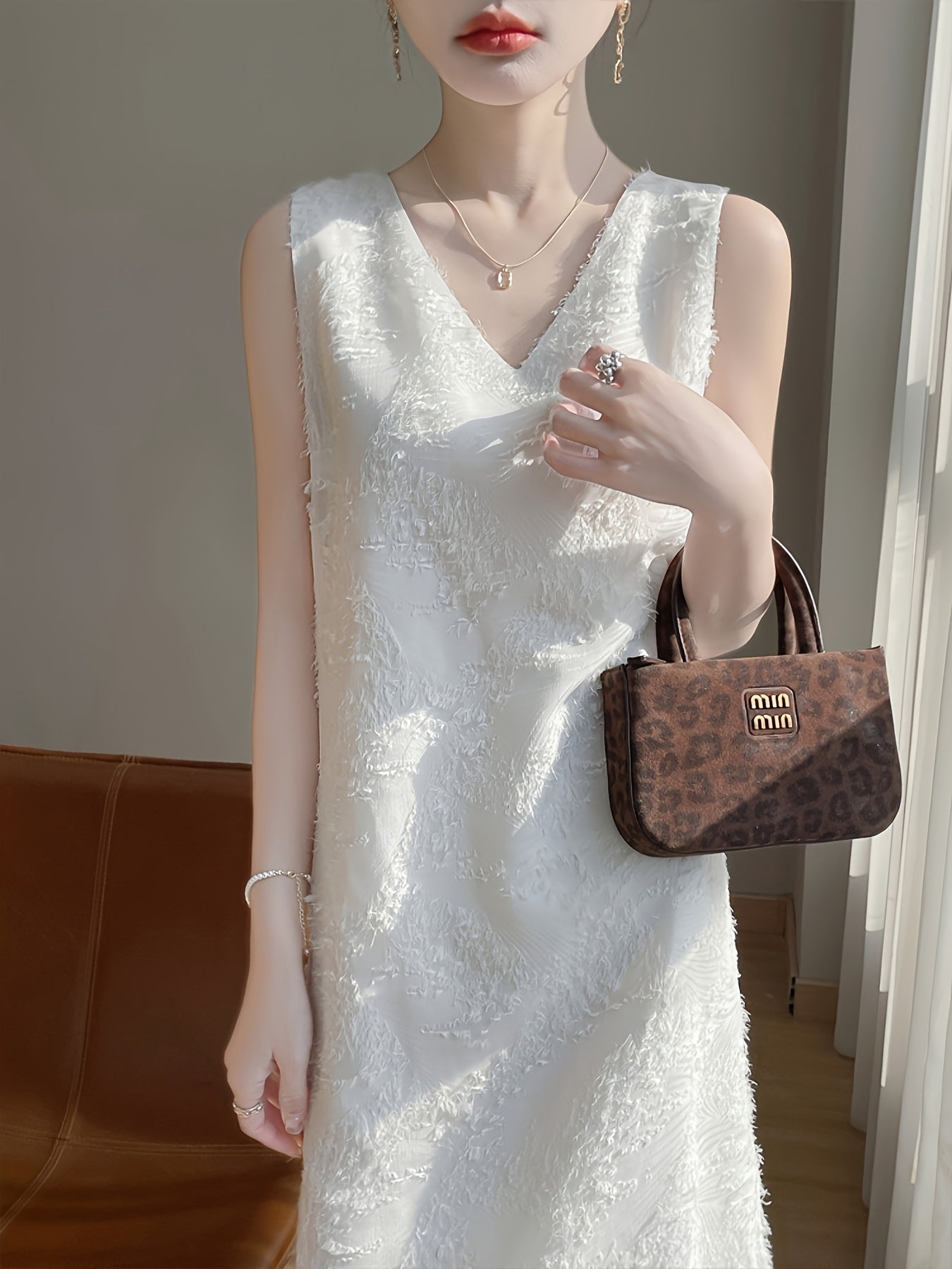 Elegantes ärmelloses Damenkleid mit frechem Ausschnitt - mit kaskadierenden Quasten